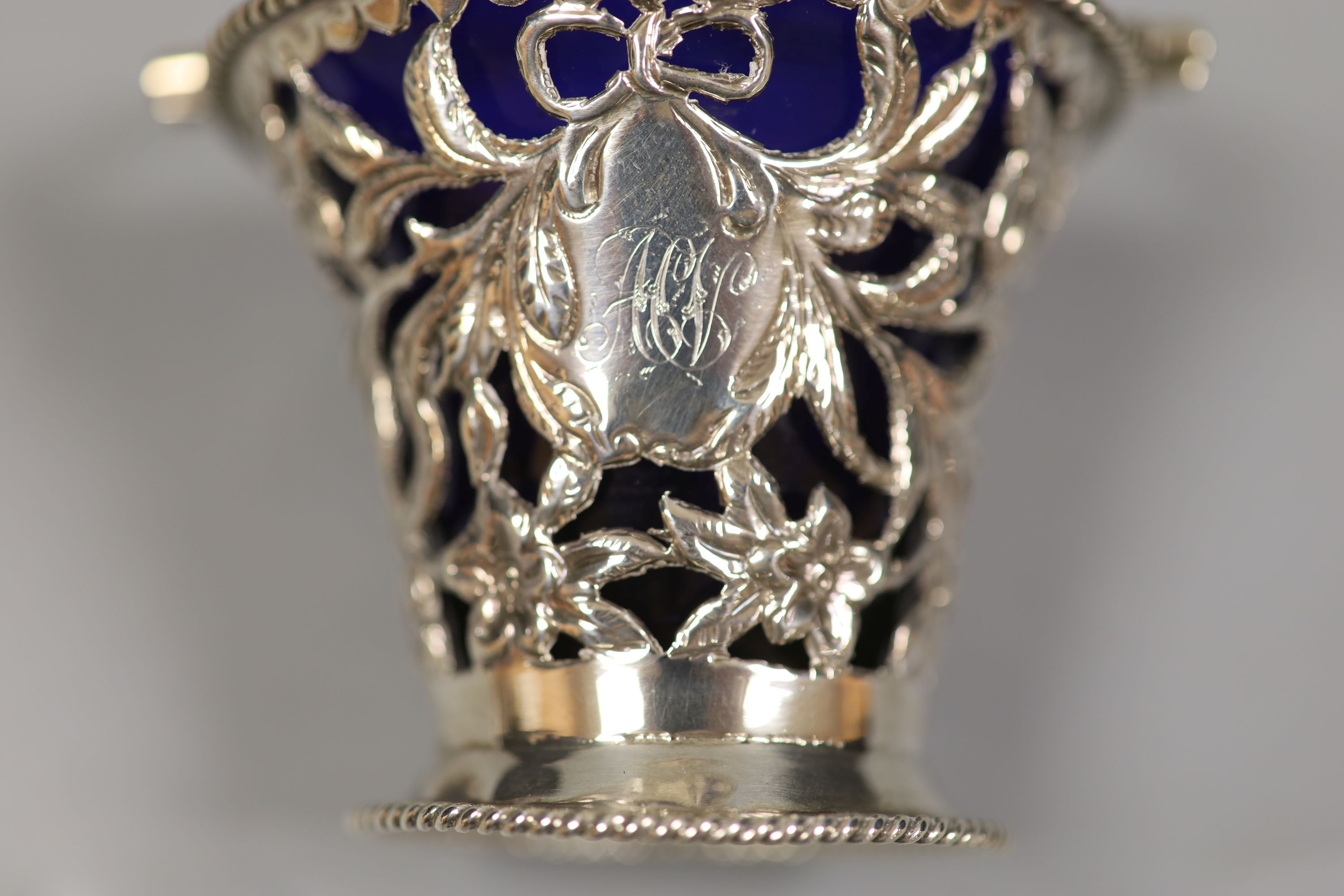 A late Victorian pierced pale-shaped small sugar basket, with cobalt glass liner, William Henry Skinner, London, 1899, height 67mm.